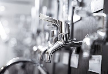 Rows of metal water taps at the showroom of a large store.