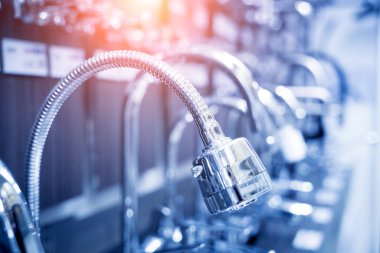 Rows of metal water taps at the showroom of a large store.