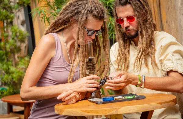Hippie Style Couple Smoking Medical Marijuana Using Bong — Foto Stock