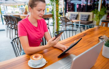 Cafe 'de QR kodlu cep telefonuyla ulaşılamaz ödeme yapan bir kadın..