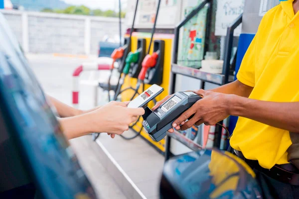 stock image Woman using contactless payment by mobile phone with QR code at car filling station.