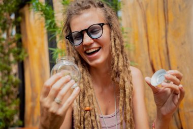 Hippi tarzı bir kadın tıbbi marihuana eklemlerini ve tomurcuklarını inceliyor.