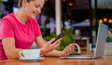 Cafe 'de QR kodlu cep telefonuyla ulaşılamaz ödeme yapan bir kadın..