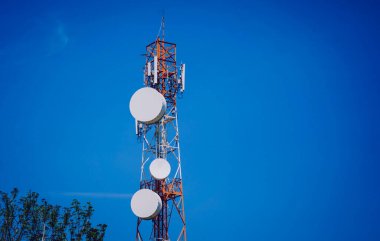 Gökyüzü arka planında akıllı cep telefonu için 5G baz istasyonu.