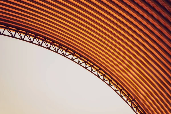 Abstract background spiral metal arch on blue sky.