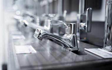 Rows of metal water taps at the showroom of a large store.