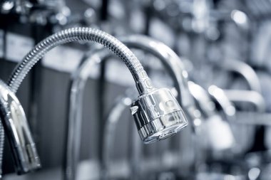 Rows of metal water taps at the showroom of a large store.