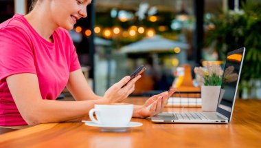 Cafe 'de QR kodlu cep telefonuyla ulaşılamaz ödeme yapan bir kadın..