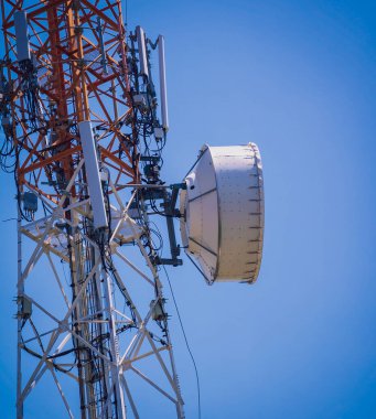 Gökyüzü arka planında akıllı cep telefonu için 5G baz istasyonu.