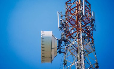 Gökyüzü arka planında akıllı cep telefonu için 5G baz istasyonu.