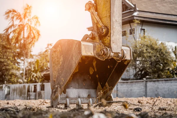 stock image Excavator with shovel digs the ground for the foundation at constuction area