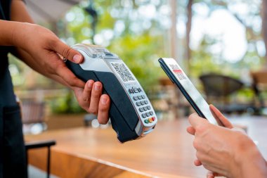 Cafe 'de QR kodlu cep telefonuyla ulaşılamaz ödeme yapan bir kadın..