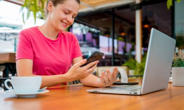 Cafe 'de QR kodlu cep telefonuyla ulaşılamaz ödeme yapan bir kadın..