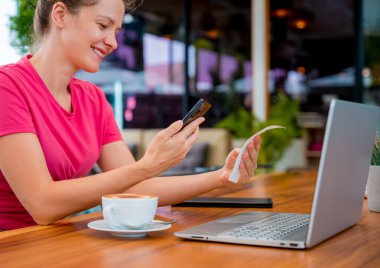 Cafe 'de QR kodlu cep telefonuyla ulaşılamaz ödeme yapan bir kadın..