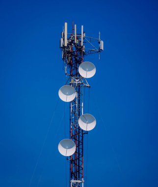Gökyüzü arka planında akıllı cep telefonu için 5G baz istasyonu.