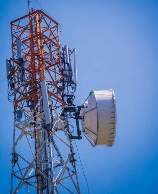 Gökyüzü arka planında akıllı cep telefonu için 5G baz istasyonu.