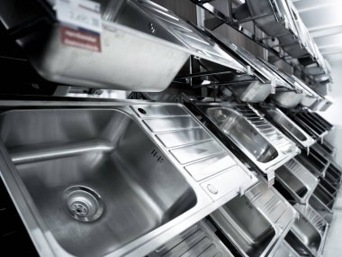Geniş bir mağazanın galerisindeki metal mutfak lavabosunun açısı.