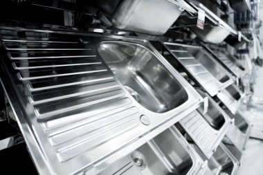 Geniş bir mağazanın galerisindeki metal mutfak lavabosunun açısı.