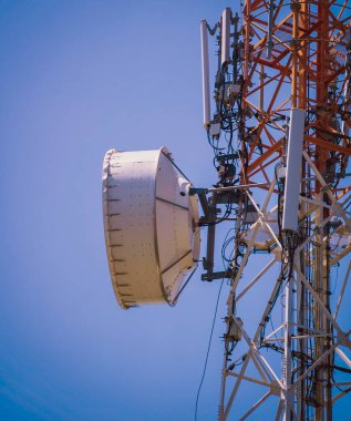 Gökyüzü arka planında akıllı cep telefonu için 5G baz istasyonu.