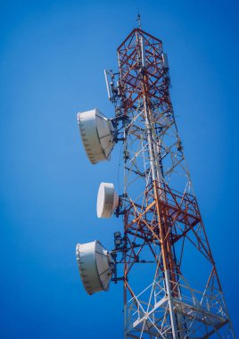 Gökyüzü arka planında akıllı cep telefonu için 5G baz istasyonu.