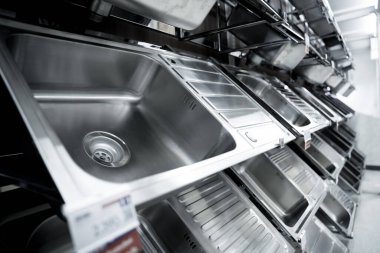 Geniş bir mağazanın galerisindeki metal mutfak lavabosunun açısı.