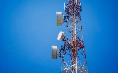 Gökyüzü arka planında akıllı cep telefonu için 5G baz istasyonu.