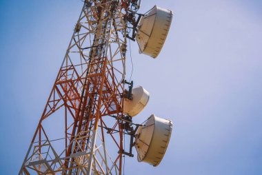 Gökyüzü arka planında akıllı cep telefonu için 5G baz istasyonu.