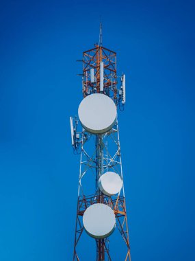 Gökyüzü arka planında akıllı cep telefonu için 5G baz istasyonu.