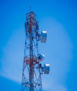 Gökyüzü arka planında akıllı cep telefonu için 5G baz istasyonu.