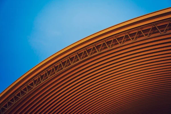 Abstract background spiral metal arch on blue sky.