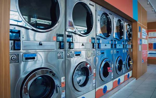 Rows of industrial laundry machines in the large laundromat