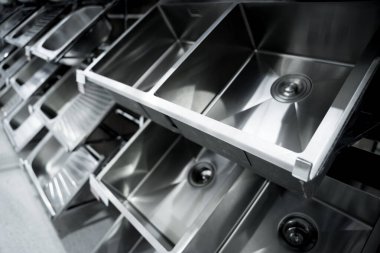 Geniş bir mağazanın galerisindeki metal mutfak lavabosunun açısı.