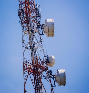 Gökyüzü arka planında akıllı cep telefonu için 5G baz istasyonu.