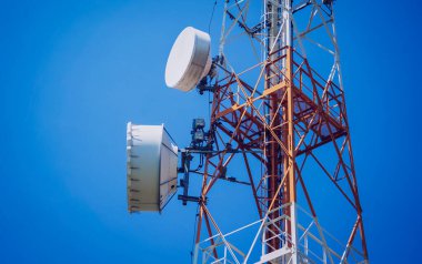 Gökyüzü arka planında akıllı cep telefonu için 5G baz istasyonu.