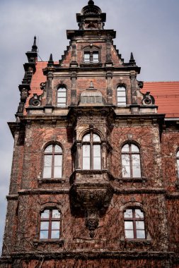 Klasik pencere ve kapıları olan eski bir Avrupa tarihi binasının cephesi.