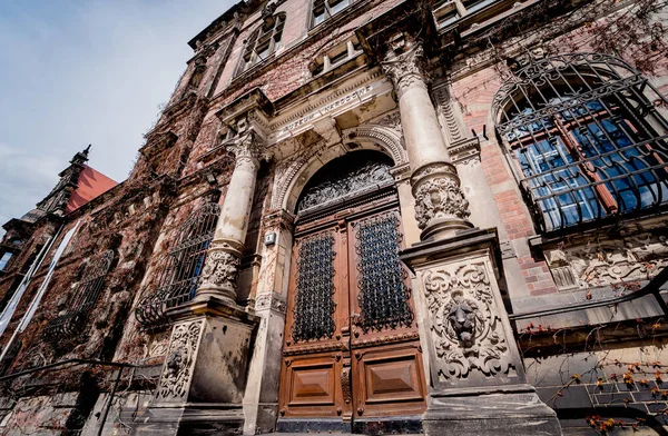 Klasik pencere ve kapıları olan eski bir Avrupa tarihi binasının cephesi.