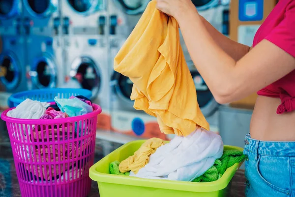 若い美しい女性は洗濯で服を洗って乾かします — ストック写真