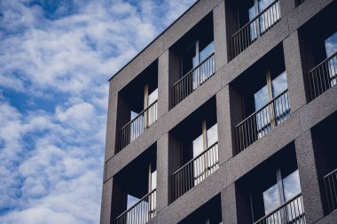 Gökyüzü arka planında cam cepheli modern bina.