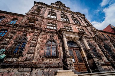 Klasik pencere ve kapıları olan eski bir Avrupa tarihi binasının cephesi.