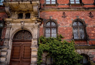 Klasik pencere ve kapıları olan eski bir Avrupa tarihi binasının cephesi.