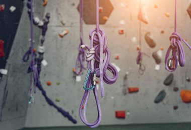 Renkli tutacakları ve ipleri olan yapay tırmanma duvarı.