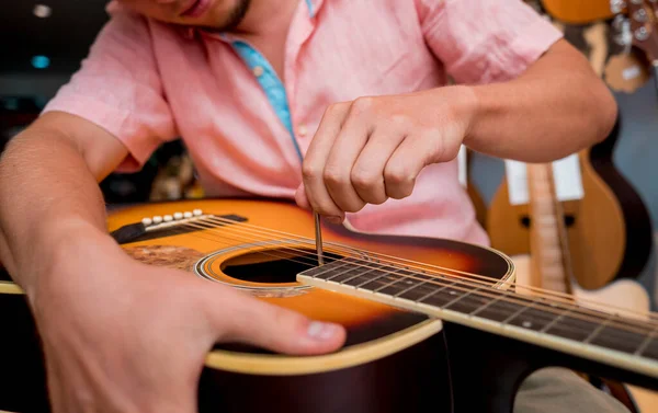 Молодой Музыкант Настраивает Классическую Гитару Магазине Гитар — стоковое фото