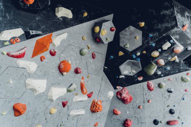 Renkli tutacakları ve ipleri olan yapay tırmanma duvarı.