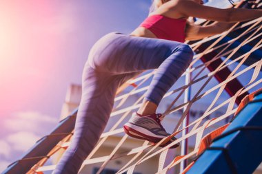 Atletik genç bayan antrenman kampında çalışıyor ve tırmanıyor.