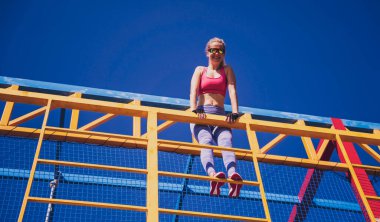 Atletik genç bayan antrenman kampında çalışıyor ve tırmanıyor.