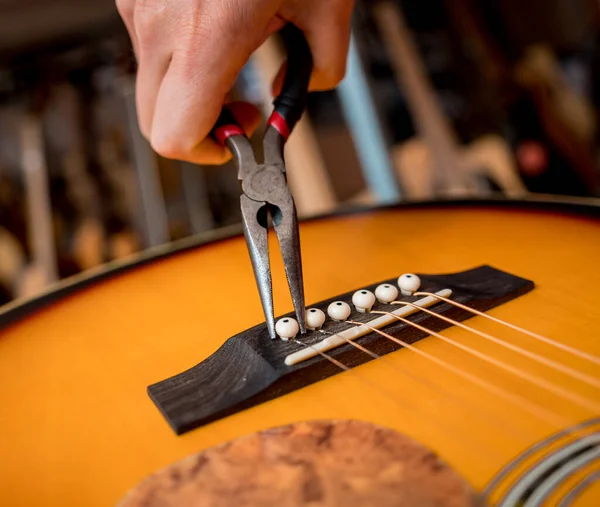ギターショップでクラシックギターの弦を変える若い音楽家 — ストック写真