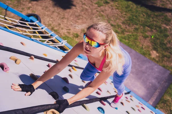 stock image Athletic young woman working out and climbing a ropes at the rope training camp