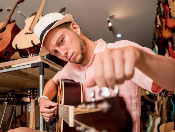 가게에서 클래식 기타를 조율하는 음악가 — 스톡 사진