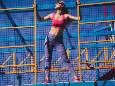 Atletik genç bayan antrenman kampında çalışıyor ve tırmanıyor.