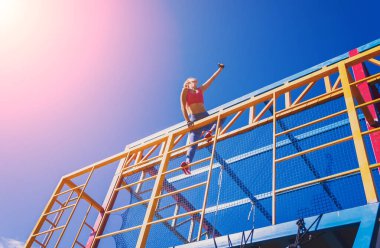 Atletik genç bayan antrenman kampında çalışıyor ve tırmanıyor.